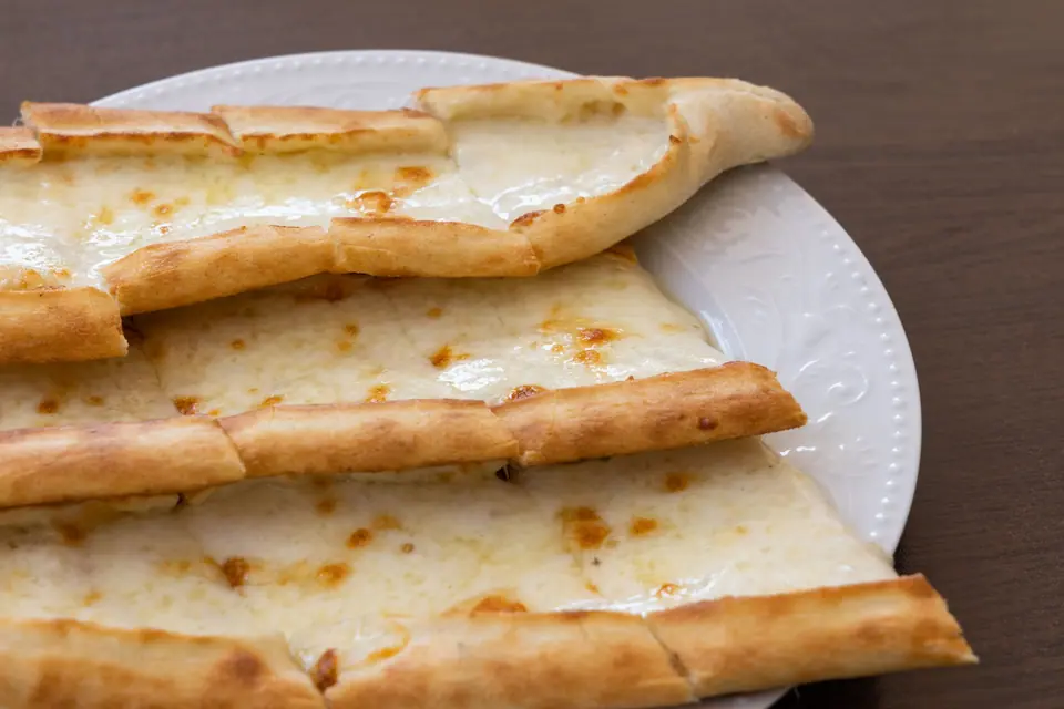 Close-up Shot of Cheese Pide on Ceramic Plate