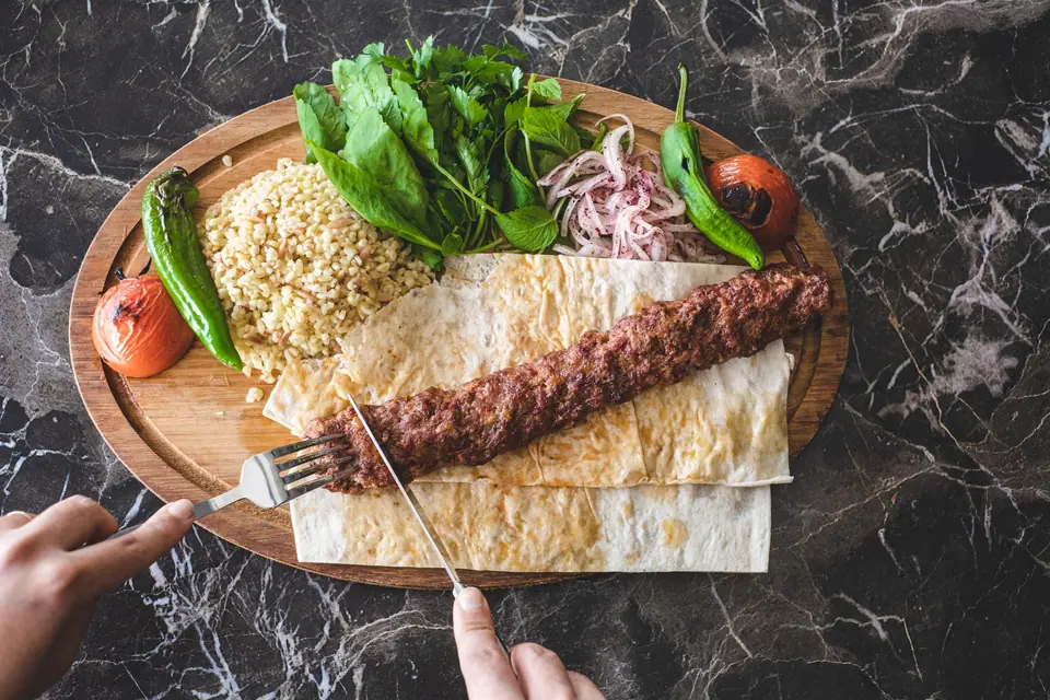 Close-Up Shot of a Person Slicing a Kebab